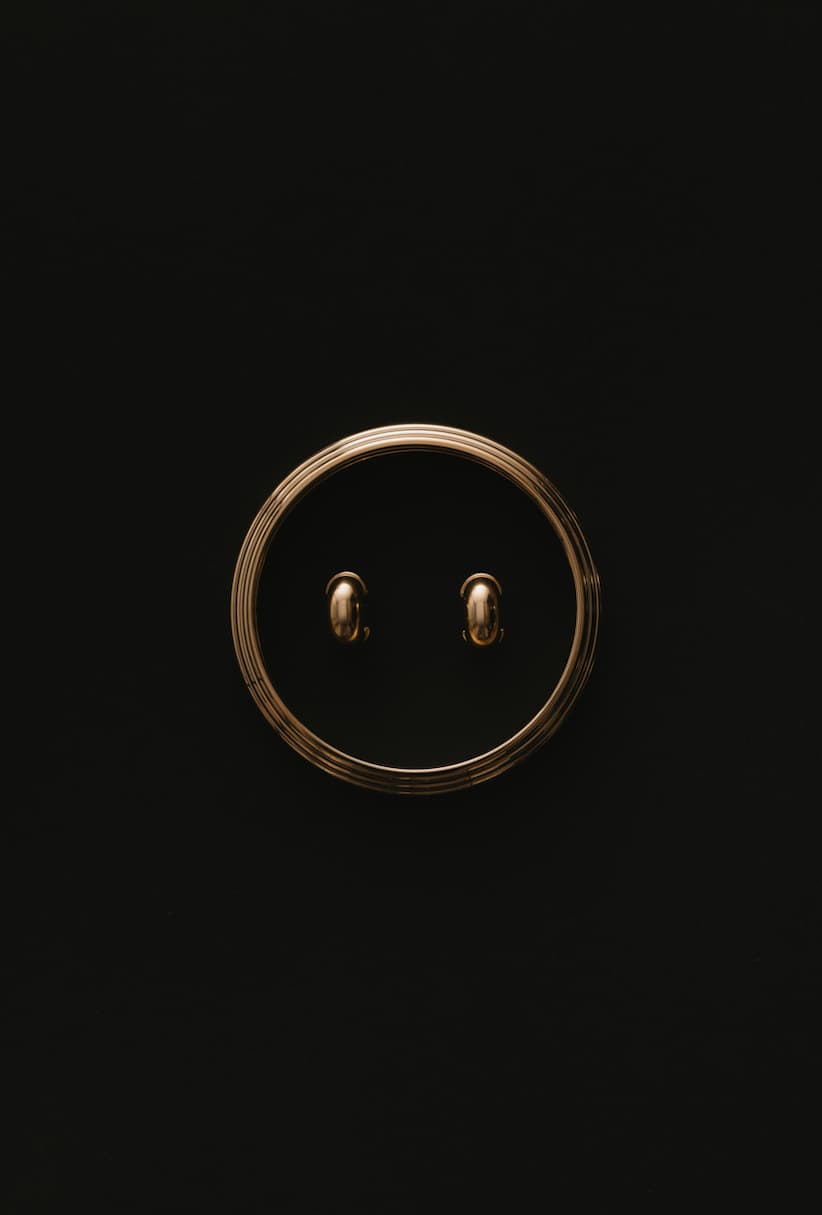 Gold modern jewelry on black background by Maslo