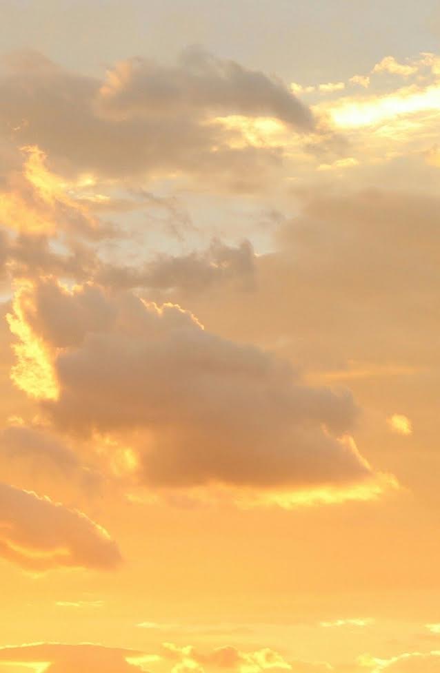 Warm gold sky during sunset with white clouds